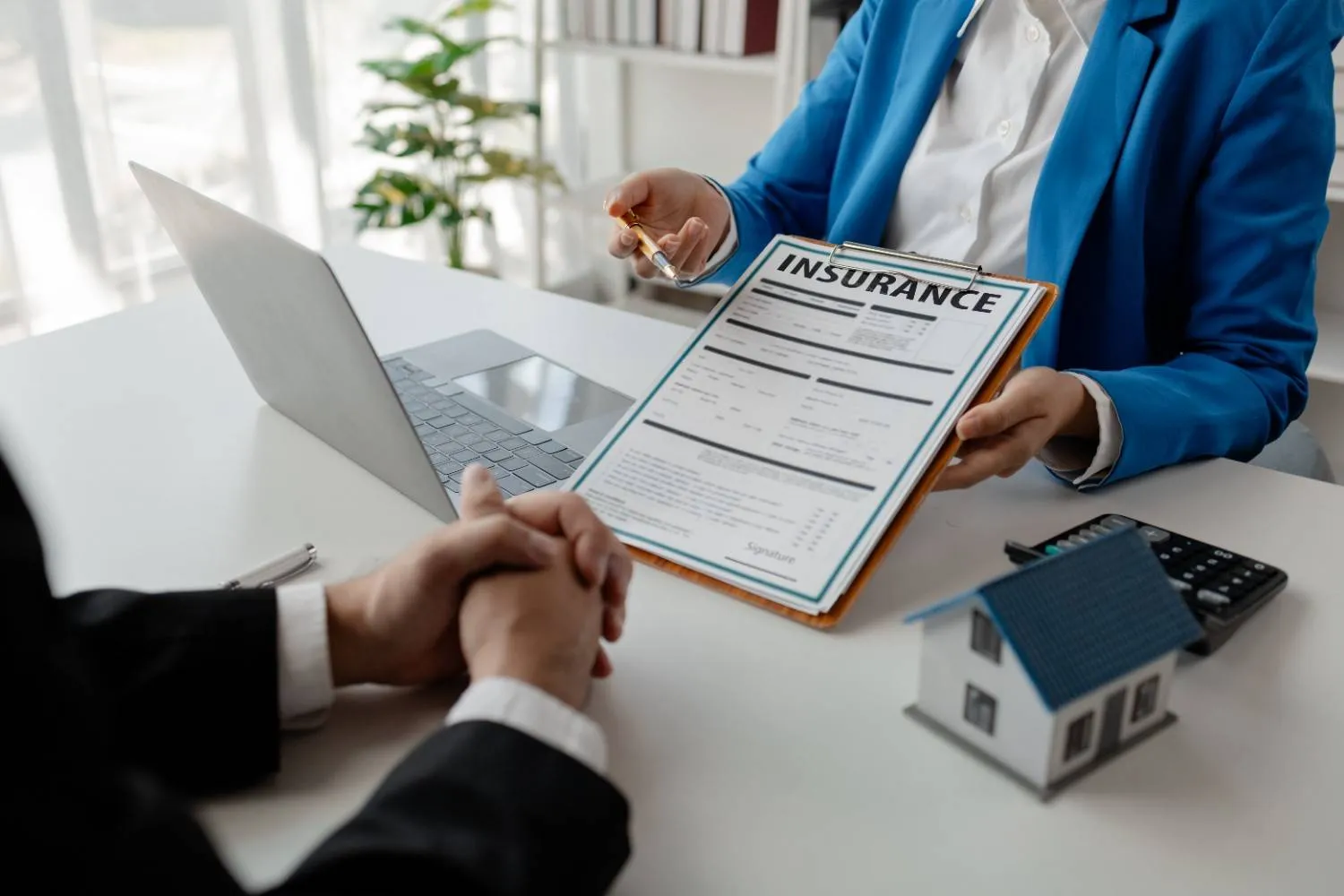 Home insurance policy being reviewed page by page across a desk